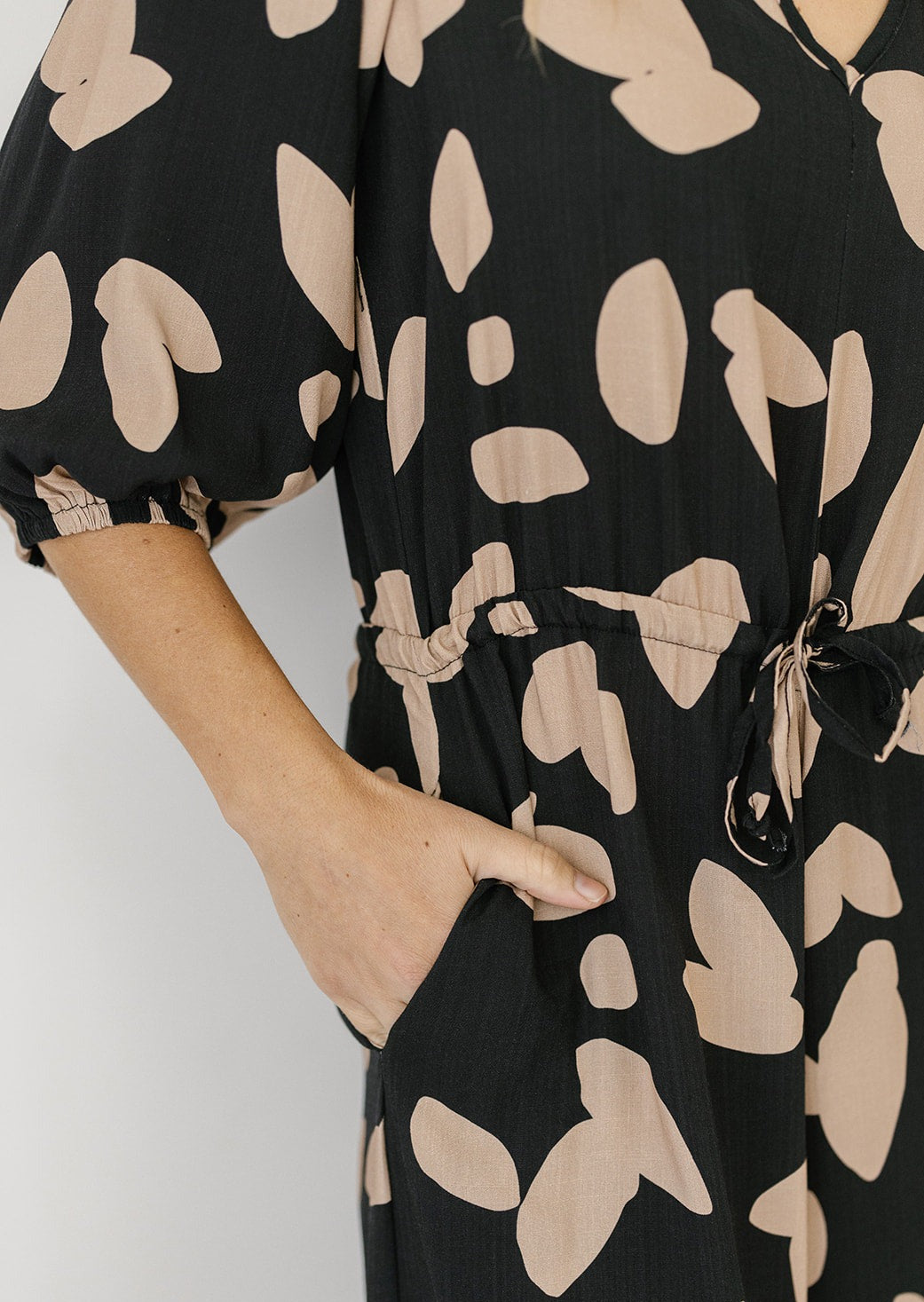 black petal print jumpsuit with drawstring waist and pockets