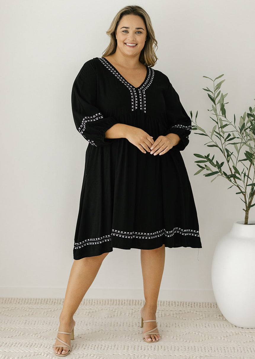 black knee-length smock-style dress with pockets